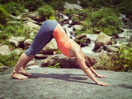 jong sportief fit vrouw aan het doen yoga oudoors Bij tropisch waterval foto