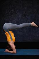 vrouw aan het doen hatha yoga Ashtanga Vinyasa yoga asana sirsasana urd foto