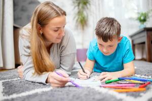 gelukkig familie spelen samen Aan vloer. moeder en zoon schilderij samen foto