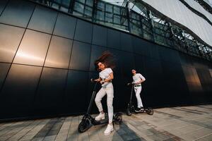 een meisje en een vent zijn wandelen Aan elektrisch scooters in de omgeving van de stad, een paar in liefde Aan scooters. foto