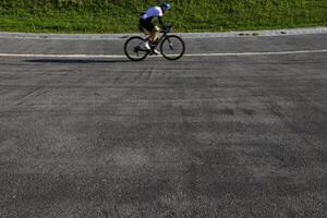 een fietser opleiding Aan de wielrennen bijhouden in de park. gezond levensstijl foto