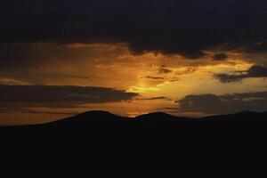 zonsopkomst of zonsondergang over- de heuvels of bergen. ochtend- of avond achtergrond foto