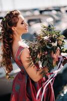 jong model- meisje in een mooi jurk met een boeket van bloemen Aan de strand in Frankrijk. meisje met bloemen in voorjaar provence Aan de Frans riviera foto