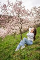 lief jong vrouw in een bloeiend roze en wit tuin petrin in Praag, voorjaar tijd in Europa. hoog kwaliteit foto