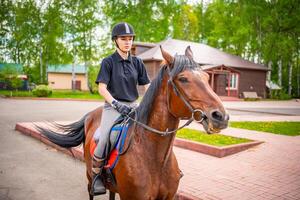 lief jong vrouw vervelend helm rijden haar bruin paard foto