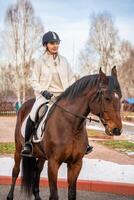 mooi blond professioneel vrouw jockey rijden een paard Aan boerderij foto