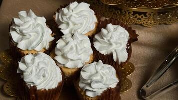 een goud bord bekroond met cupcakes en een zilver lepel foto