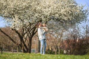 jong moeder en haar schattig dochter hebben een pret in voorjaar tijd park in Praag, Europa foto