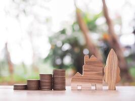 miniatuur huis en stack van munten. de concept van besparing geld voor huis, eigendom investering, huis hypotheek, echt landgoed foto