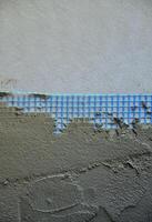 de structuur van de muur, gedekt met grijs schuim polystyreen platen, gedekt met een blauw versterken maas en gedekt met een mengsel voor lijmen het. stadium van muur isolatie foto