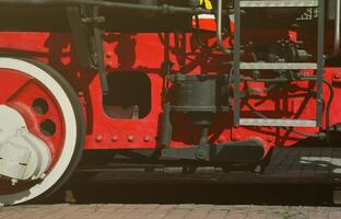 wielen van de oud zwart stoom- locomotief van Sovjet keer. de kant van de locomotief met elementen van de roterend technologie van oud treinen foto