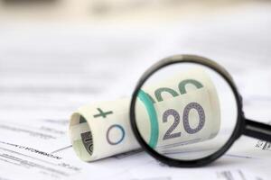 Pools zloty geld en vergroten glas Aan groot bedrag van Pools belasting vormen dichtbij omhoog. boekhouding, bureaucratie en belastingbetalers routine- foto