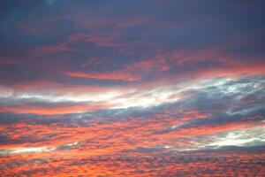 gouden schemering, een spectaculair zonsondergang lucht met geschilderd wolken foto