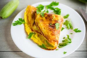 gebakken omelet met courgette, Aan een houten tafel. foto