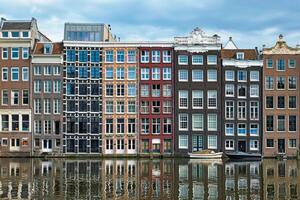 Amsterdam kanaal damrak met huizen, Nederland foto