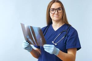 vrouw dokter analyses röntgenstraal afbeeldingen van patiënten gewond been Aan een blauw achtergrond foto