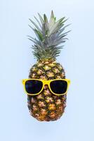 ananas met zonnebril Aan blauw achtergrond foto