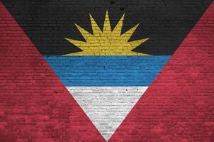 antigua en Barbuda vlag afgebeeld in verf kleuren Aan oud steen muur. getextureerde banier Aan groot steen muur metselwerk achtergrond foto