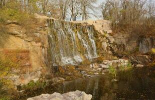 mooi waterval tussen groot rotsen in herfst Woud. sofievskij park in uman, Oekraïne foto