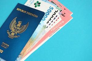blauw republiek Indonesië paspoort met geld en vliegmaatschappij kaartjes Aan blauw achtergrond dichtbij omhoog foto