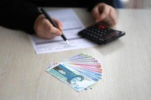 accountant begin naar vullen Iraans belasting het formulier Aan kantoor tafel. belastingheffing periode en jaar- belastingbetalers routine- foto