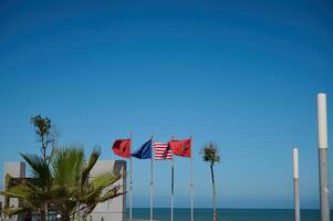 marokkaans, Spaans, Europese unie, Verenigde Staten van Amerika en Super goed Brittannië vlaggen over- blauw lucht achtergrond foto