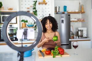 jong Afrikaanse Amerikaans vrouw Koken spreker pratend Aan digitaal camera opname vloggen. Afrikaanse vrouw vlogger of het schieten blog filmen reportage reclame video, coachen. foto