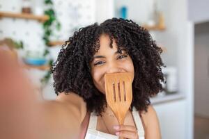 jong Afrikaanse Amerikaans vrouw voedsel blogger nemen een selfie met een lasser foto