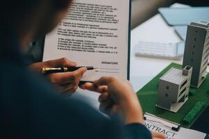 makelaar sprak over de voorwaarden van de koopovereenkomst voor het huis en vroeg de klant om de documenten te ondertekenen om het contract legaal, woningverkoop en woningverzekeringsconcept te maken. foto