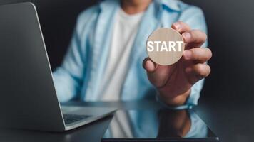 zakenman tonen cirkel houten en begin belettering Aan bureau met computer en tablet, beginnend een nieuw bedrijf, planning naar begin een bedrijf, bedrijf doel van toekomst. foto