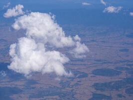 luchtfoto van land en wolken gezien door vliegtuigraam foto