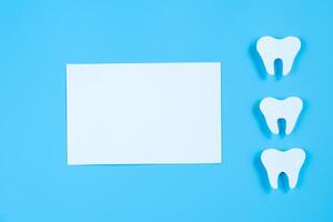 papier besnoeiing mockup van tand Aan blauw achtergrond. tandheelkundig zorg concept. Internationale tandarts dag. foto