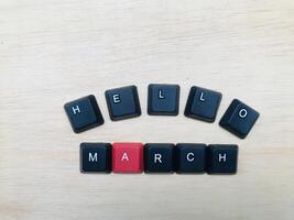 top visie van zwart toetsenbord met woord Hallo maart Aan houten achtergrond. foto