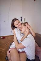 een jong paar in huis kleren voorzichtig knuffel in de leven kamer, minimalisme foto