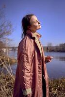 portret van een mooi jong vrouw Aan de rivier- bank foto