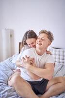 jong paar Aan bed, vrouw knuffels Mens van achter foto