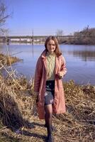 portret van een mooi jong vrouw Aan de rivier- bank foto