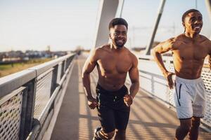 twee Afro-Amerikaans vrienden zijn jogging Aan de brug in de stad. foto