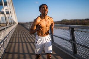 jong Afro-Amerikaans Mens is jogging Aan de brug in de stad. foto