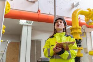 onderhoud technicus Bij een verwarming fabriek, petrochemie arbeiders toezicht houden de operatie van gas- en olie pijpleidingen in de fabriek, ingenieurs zetten horen beschermer Bij kamer met veel pijpen foto