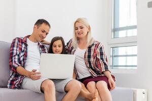 glimlachen jong ouders en hun kind zijn heel Vrolijk, ze zijn Bij huis foto