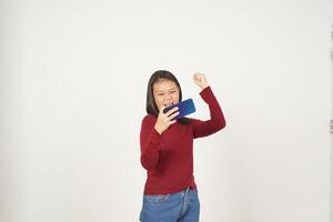 jong Aziatisch vrouw in rood t-shirt spelen mobiel spel Aan smartphone geïsoleerd Aan wit achtergrond foto