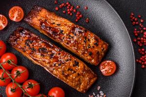 heerlijk rood Zalm vis gegrild met saus en sesam, specerijen en kruiden foto