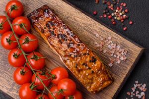 heerlijk rood Zalm vis gegrild met saus en sesam, specerijen en kruiden foto