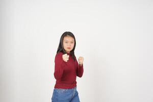 jong Aziatisch vrouw in rood t-shirt ponsen vuist naar strijd geïsoleerd Aan wit achtergrond foto