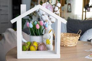 klein huis van knus huis met Pasen decor met konijn en eieren Aan tafel van keuken. gebouw, ontwerp, projecteren, in beweging naar nieuw huis, hypotheek, verzekering, huur en aankoop echt landgoed foto