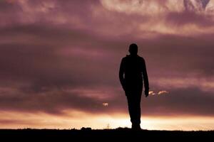 Mens silhouet in de platteland en zonsondergang achtergrond foto