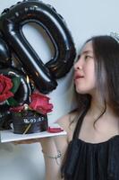mooi vrouw vervelend een zwart jurk en chocola taart in de concept van verjaardag foto