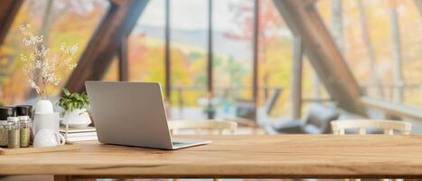 een laptop computer Aan een houten dining tafel in de modern knus cabine huis leven kamer. foto