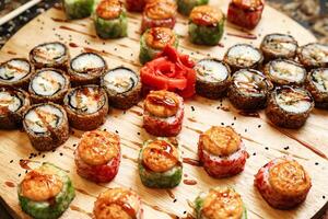 houten schotel overlopend met geassorteerd sushi broodjes foto